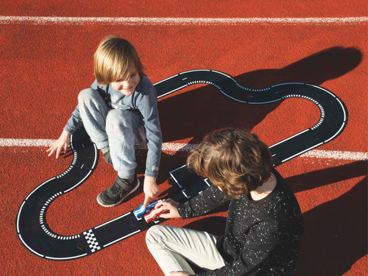 Kinderen spelen met Waytoplay Grand Prix racebaan op een atletiekpiste