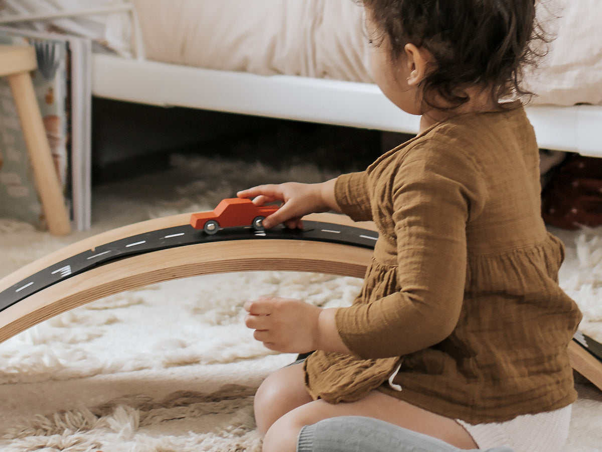 Kind speelt met de Waytoplay Heen en Weer Auto Oranje op een Waytoplay weg