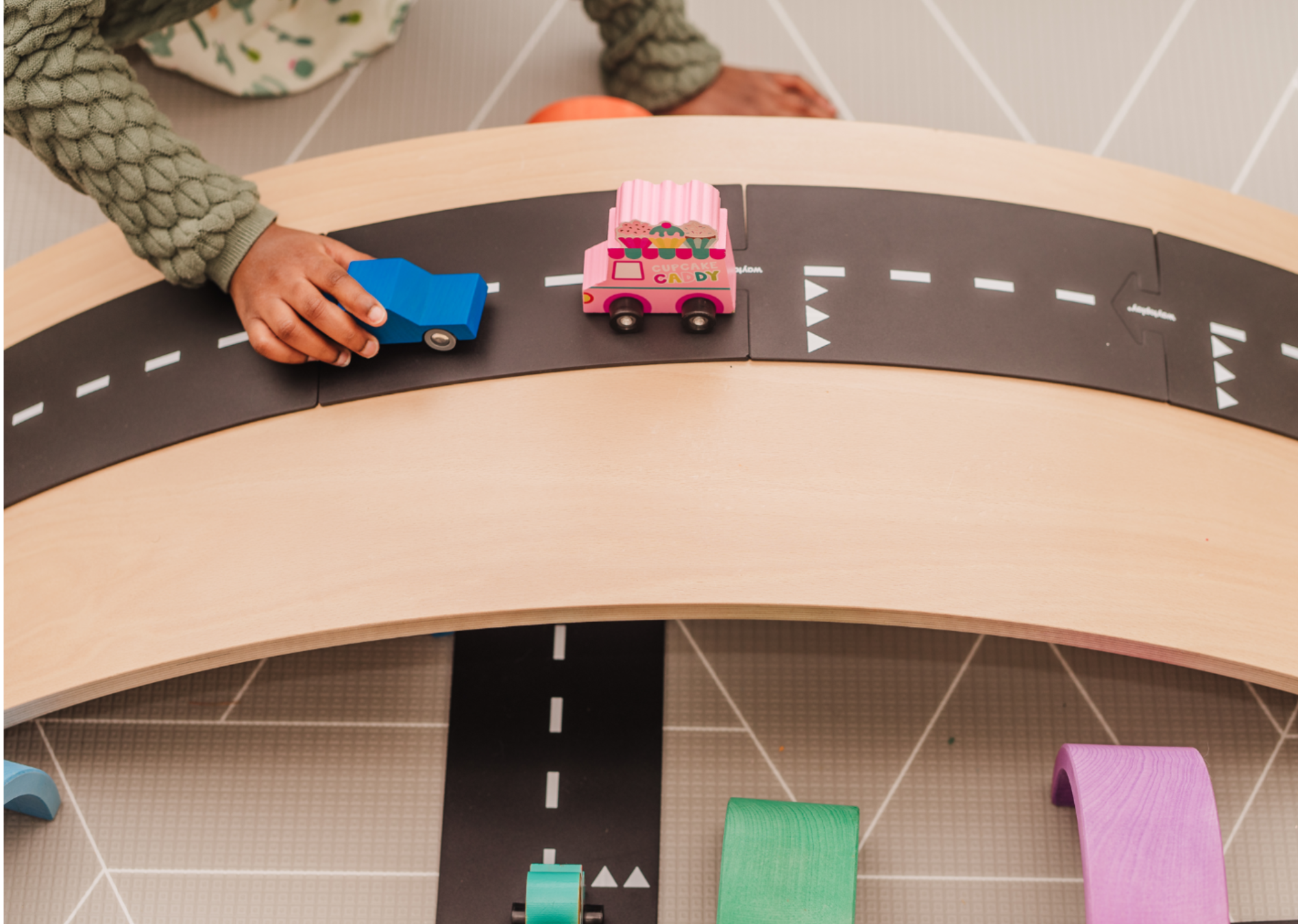 Kind rijdt met een autootje over een Waytoplay weg op een Wobbel tijdens vrij spel