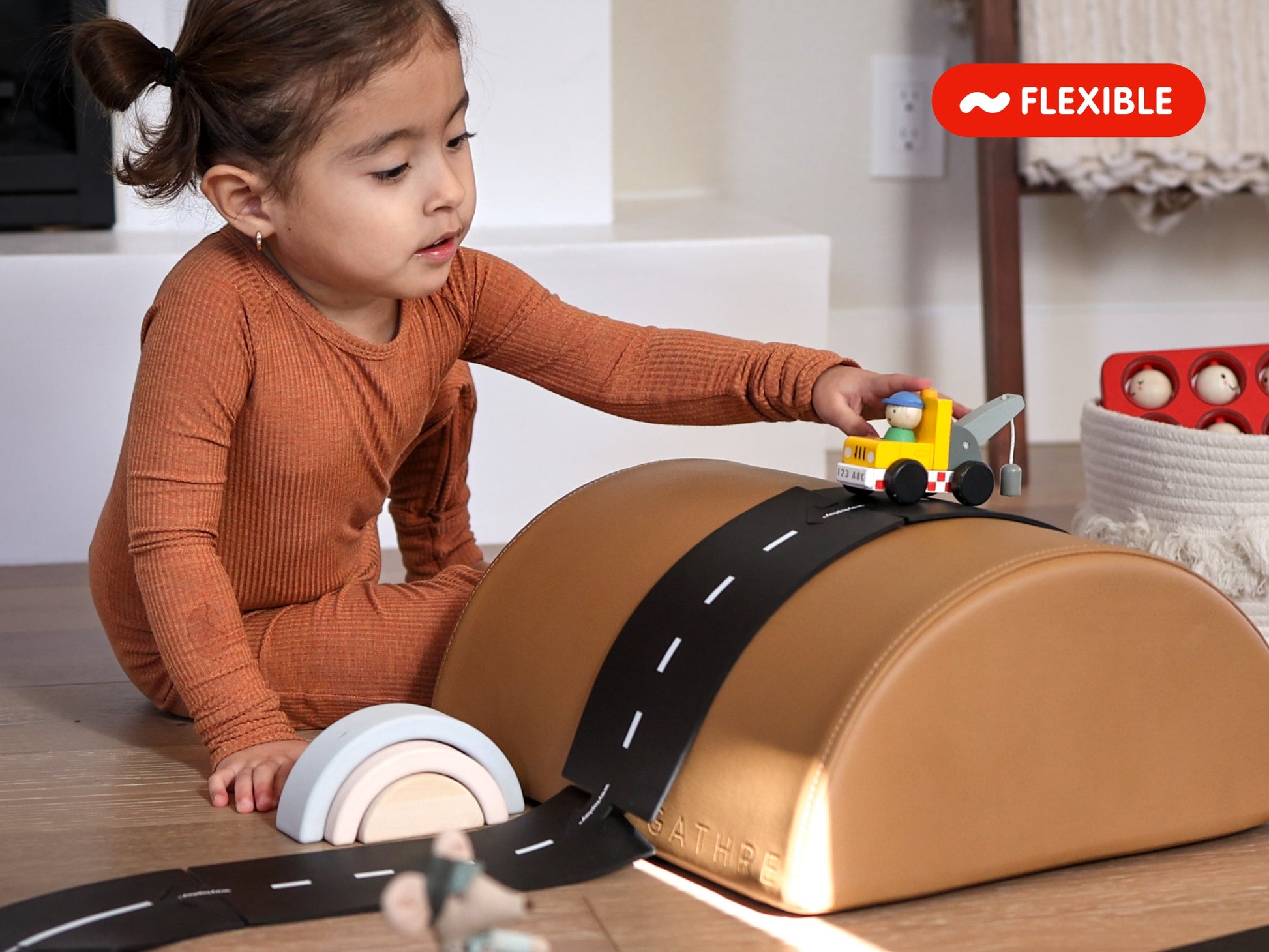 Kind speelt met Waytoplay Ringroad flexibele autobaan over een speelboog binnenshuis