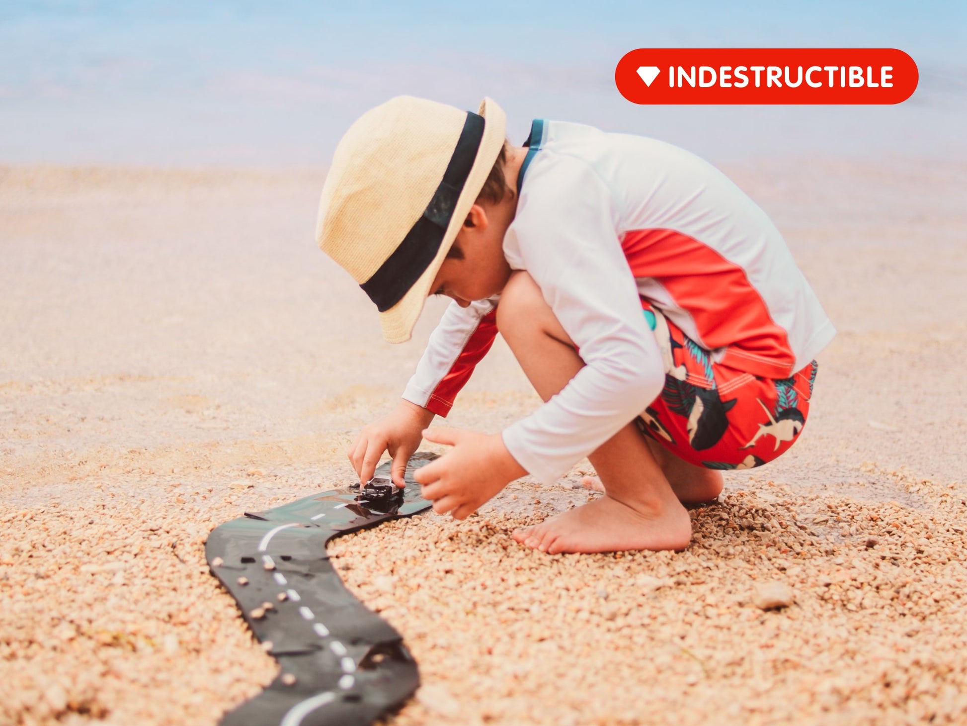 Kind speelt buiten met Waytoplay Ringroad flexibele autobaan op het strand